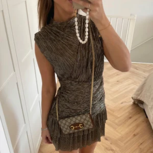 Glittrig kortklänning - It Girl klänning från ByNicci i färgen guld/silver. Klänningen är nyligen köpt och använd endast en gång, inga defekter!😊 Är i storlek XS/S men passar även M då den är av stretchigt material! Perfekt för fester🎉 Frågor ställs och besvaras via DM! Obs! Första bilden är lånad, de två därefter är egna.