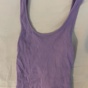 Lila ribbad linnetopp från BikBok.  - Säljer en snygg lila ribbad linnetopp från BikBok i storlek XS. Perfekt för varma dagar med sin ärmlösa design och mjuka material. Säljer toppen för 50kr💜