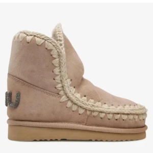 Beige boots från Mou - Säljer ett par mysiga beige boots från Mou  med dekorativa sömmar och logotyp i glittrigt material på hälen i storlek 38.. Perfekta för kyliga dagar med sin varma insida!! Skriv för frågor mm😊