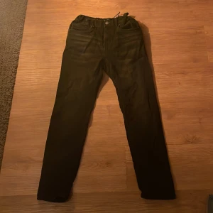 Svarta byxor från Lindex - Snygga svarta byxor från Lindex med en regular passform. Byxorna har en klassisk design med knappar och dragkedja. Perfekta för en stilren look.😄