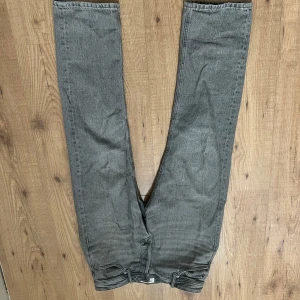 Jack & Jones jeans - Snygga grå jeansbyxor med en klassisk design. De har en rak passform och är perfekta för en avslappnad stil. Byxorna har en dragkedja och knappar framtill.