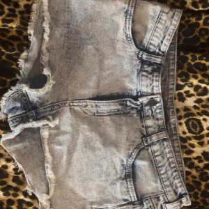 Grå jeansshorts från Divided H&m  - Säljer ett par grå jeansshorts från h&m med slitna kanter och klassisk femficksdesign. Väldigt små i storleken står 38 men skulle säga mer 34/32