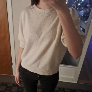 Beige tröja från Vero Moda - Säljer en stilren beige tröja från Vero Moda. Tröjan har puffiga trekvartsärmar och en rund halsringning. Perfekt för en avslappnad look.