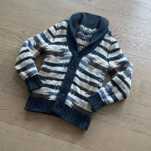 Gran Sasso cardigan  - Säljer en snygg randig kofta från Gran Sasso i blå, brun och beige. Koftan har en djup krage och knappar framtill. Perfekt för kyliga dagar med sin stickade design och långa ärmar.