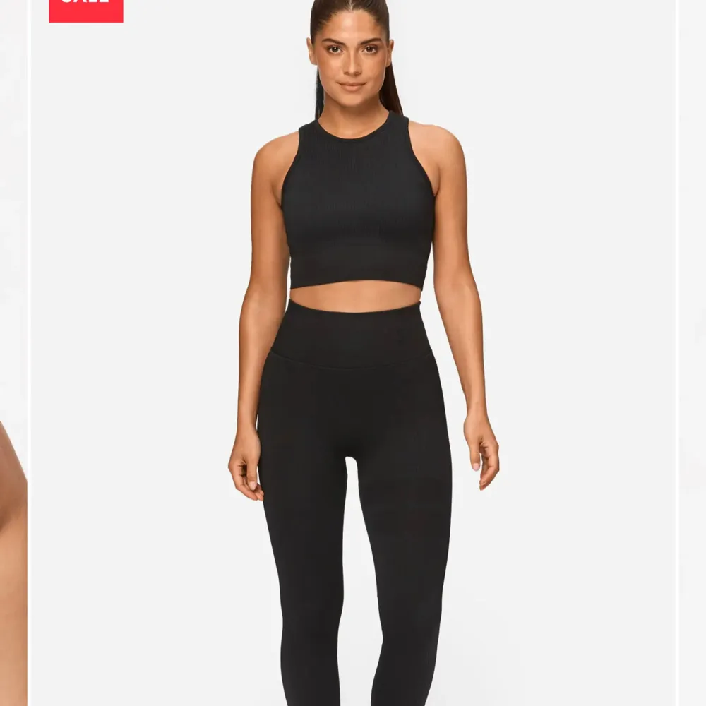 Snygg svart ribbad träningstopp från Stronger med hög halsringning och ärmlös design. Perfekt för träning eller en avslappnad dag. Den croppade längden ger en modern look. Använd ett få tal gånger! Mycket bra skick! Nypris 399!. Yläosat.