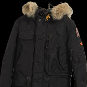 Svart parajumper jacka med äkta päls - Nu säljer jag min snygg svart parajumperjacka med pälsdetaljer på huvan, som inte kommer till andvändning längre . Jackan har flera praktiska fickor och en stilren design. Jackan är köpt på johnhells ny pris ungefär 5000kr. Säljer den för 2499kr, pris går förståss att diskutera. Jackan är i storlek Xs men passar mig som är 170 men den är lite liten.Skulle sagt att den passar någon som är ungefär mellan 160-168 cm. Fler bilder finns vid önskning. Äkthetsbevis finns samt extra logga och knappar.