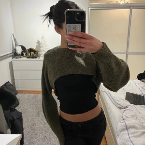 Olivgrön stickad croppad tröja - Säljer en olivgrön stickad tröja med croppad design. Tröjan har långa ärmar och en mysig, mjuk textur. Perfekt för lager-på-lager-stil eller som statement-plagg. Jag är i vanliga fall en Xs men då den är superstretchig passar den både S/XS/M/L!