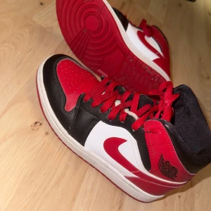 Nike Air Jordans i rött och svart - Snygga Nike Air Jordans i en klassisk färgkombination av rött, svart och vitt. Skorna har en hög modell med snörning och den ikoniska Jumpman-loggan på plösen. Storlek 36,5 köpte de för 1200 men säljer för 600 nästan helt oanvända 
