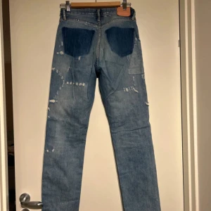 Acne S Indigo Bla Konst 1996 Vintage Patch Jeans - Snygga ljusblå jeans från Acne Studios Blå Konst med slitna detaljer och patchar. De har en rak passform. 