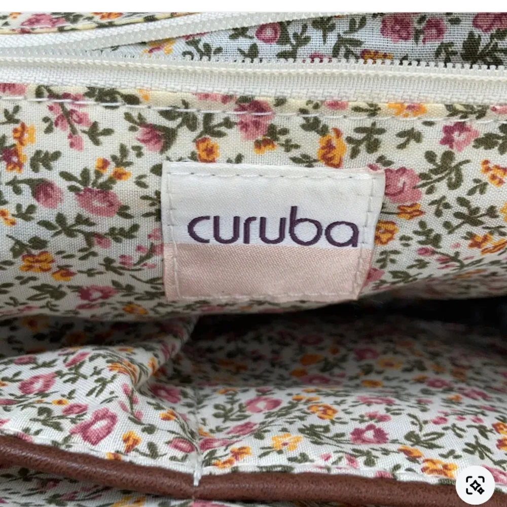 Brun handväska från Curuba med fint blommigt innertyg! Säljer då jag inte får någon användning av den. Inga defekter!💞💞. Asusteet.