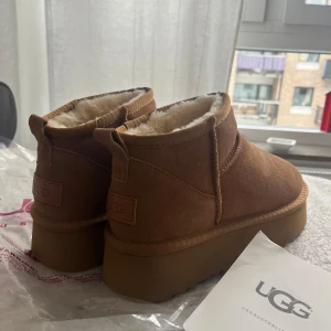 UGG platform brun 39  - Säljer ett par klassiska bruna UGG boots med mjukt pälsfoder. Perfekta för att hålla fötterna varma under kalla dagar. De har en robust sula och är tillverkade i mocka. Storlek 39! 
