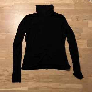 Svart polotröja från H&M - Säljer en stilren svart polotröja från H&M. Tröjan har långa ärmar och en klassisk polokrage, perfekt för kyligare dagar. Den är tillverkad i ett mjukt och bekvämt material.