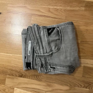 Grå jeans från Replay - Snygga grå jeans från Replay i modellen Anbass. De har en slim passform och är tillverkade i ett bekvämt denimtyg. Perfekta för en stilren look.