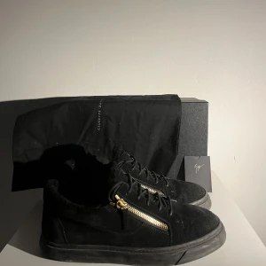 Giuseppe Zanotti sneakers - Säljer ett par snygga svarta sneakers i mocka från Giuseppe Zanotti med riktigt snygga dragkedjor på sidorna. De är i bra skick och har tagits hand om väl. Skorna har en stilren design och är de bästa sneakersen för 2025 enligt mig! Kontakta mig vid minsta fråga🙌