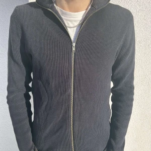 Mörkblå Zip-tröja från Jack & Jones - Mörkblå zip tröja från Jack&Jones, Tröjan har tecken på användning (lite bleknad färg) men utöver det är skicket fint! Storlek L. för referens har modellen storlek M/L i vanliga fall