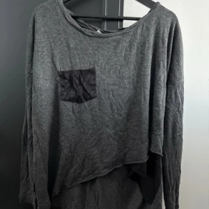 Grå tröja från Object Collectors Item - Säljer en grå tröja från Object Collectors Item i storlek S. Tröjan har en svart bröstficka och en avslappnad passform. Perfekt för en casual look.