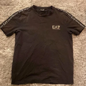 EA7 T-shirt - Säljer en svart Emporio Armani T-shirt.Tröjan är i bra skick förutom en fläck bild 5. Tröjan är i storlek XL men passar mig som har M. Skriv gärna över frågor och funderingar, priset kan diskuteras.