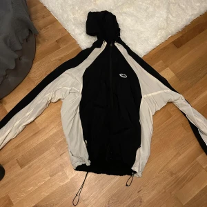 Svart och beige vindjacka från Corteiz - Säljer en svart och beige vindjacka från Corteiz med dragkedja och justerbar huva. Jackan har långa ärmar och en sportig look med kontrasterande färger. Perfekt för blåsiga dagar. 🖤