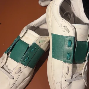 Valentino Open grön - Snygga Valentino Open sneakers i vitt med gröna detaljer. Längst bak på sulan har sjunkit lite och det finns ett litet hål under sulan men förutom det så är det bara att tvätta dom lite. Skick 6/10. Vid flera funderingar skriv gärna ⭐️