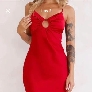 Röd klänning med cut-out detalj - Snygg röd klänning från Hello Molly med en unik cut-out detalj framtill. Klänningen har smala axelband och en figurnära passform som framhäver silhuetten. Perfekt för en kväll ute eller en speciell tillställning. Helt oanvänd med prislapp kvar. 