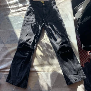 Svarta jeans med slitna detaljer🫶🏻🖤 - Snygga svarta jeans med slitna knän och flera praktiska fickor. Perfekta för en avslappnad och trendig stil. Byxorna har en loose passform och är tillverkade i ett slitstarkt material.🖤