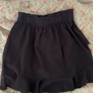 Svart volangkjol  - En svart volangkjol som är perfekt till sommaren!! Den är i storlek XS/S och säljs pga att den inte kommer till användning.💞🌸