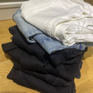 6 Blandade jeans i olika färger skinny jeans  - En samling av jeans i olika färger, inklusive vit, ljusblå och svart. Perfekt för att variera din garderob med klassiska och mångsidiga byxor. Passar till många olika stilar och tillfällen.