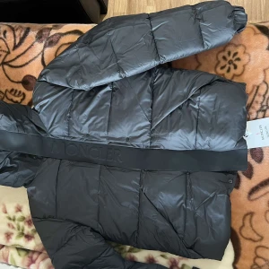 Svart pufferjacka från Moncler - Säljer en snygg svart pufferjacka från Moncler. Jackan har en quiltad design och är långärmad med en dragkedja framtill. Perfekt för kyligare dagar med sin stilrena look och varma material.