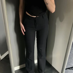 Kostymbyxor - Snygga svarta kostymbyxor med hög midja och bootcut-stil. Har i både storlek 36 och 38.