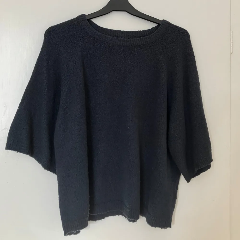 Säljer en mysig mörkblå stickad tröja med rund hals och trekvartsärmar. Perfekt för kyliga dagar och ger en avslappnad look. Passar bra till jeans eller leggings.. Neuletakit & Villapaidat.