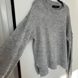Grå stickad tröja från Vero Moda - Mysig grå stickad tröja från Vero Moda. Perfekt för kyliga dagar med sin bekväma passform och långa ärmar. Enkel design som passar till det mesta. 