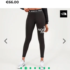 Svarta leggings från The North Face - Snygga svarta leggings från The North Face med logotyptryck på benet. De har en elastisk midja med märkets namn och en liten innerficka. Perfekta för en aktiv livsstil.