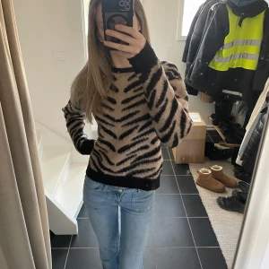 Stickad tröja  - Säljer en ”zebramönstrad” tröja från NA-KD i beige och svart. Knappt använd (av mig) dock köpt second hand. Ändå bra skick!