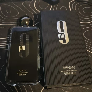 Afnan 9pm Eau de Parfum - Säljer en elegant Afnan 9pm Eau de Parfum i en stilren svart flaska med silverdetaljer. Det finns ungefär 80-90 ml av parfym kvar i flaskan. Accepterade pris: 300kr