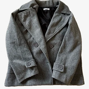 Grå Kappa Design by Si - Snygg grå kappa från design by si med dubbelknäppning och stora knappar. Perfekt för kyligare dagar. Köpte för 600 men säljer för 250. Inga defekter.