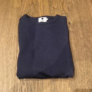 Merinoull tröja NN07 - Tja! Säljer en stilren mörkblå tröja från NN07 i storlek M men sitter som S! Tröjan är i gott skicks och har inga tecken på några defekter eller liknande! Hör av er vid frågor eller funderingar! 😁