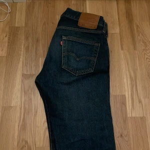 Mörkblå jeans från Levi's - Snygga mörkblå jeans från Levi's med klassisk femficksdesign och en läderpatch på baksidan. Perfekta för en avslappnad stil.