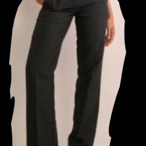 Svarta kostymbyxor - Eleganta svarta kostymbyxor med låg midja och rak passform. Perfekta för en stilren look. Helt nya med prislapp kvar. Orginal pris är 499.