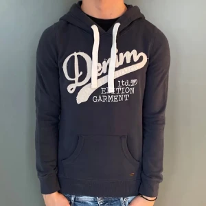 Denim Hoodie  - Tja, jag säljer min Denim Hoodie då jag har växt ur den. Hoodien är i mycket bra skick eftersom den inte hann komma till så mycket användning. Killen på bilden är 175 cm. Den är i storlek S men passar även XS. 