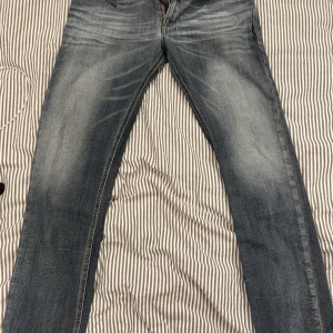 Jeans från Diesel - Snygga jeans från Diesel med en klassisk femficksdesign och lätt slitna detaljer. De har en knappgylf och är perfekta för en avslappnad stil. Märket 'Shioner' syns på insidan.