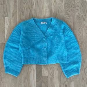 Turkos stickad kofta från Weekday - Stickad oversized ulltröja i modellen Hillevi Cardigan från Weekday. Inga fläckar, lösa trådar, nopprigt tyg eller andra skavanker.