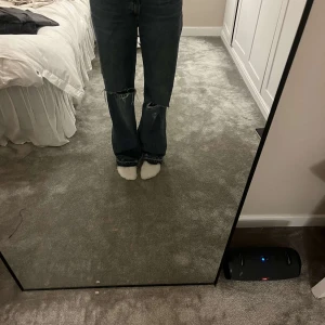 Blå jeans från Zara - Säljer ett par blå jeans från Zara med slitna detaljer. De har en bootcut-stil och är tillverkade i denim. De är låg midjade men det framkommer inte på bilden.