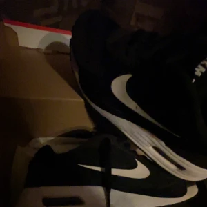 Svarta och vita Nike Air Max - Säljer ett par klassiska Nike Air Max i svart och vitt. Skorna har den ikoniska Air Max-sulan och en tydlig Nike-logga på sidan. Perfekta för både stil och komfort. 350 för dom