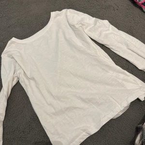 Vit och svart långärmad topp - Säljer en stilren vit och svart långärmad topp i mjukt material. Perfekt för lager-på-lager eller att bära som den är. Enkel och tidlös design som passar till det mesta.