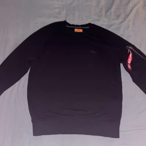 Alpha Industries Tjocktröja - Detta är en väldigt fin och bekväm tjocktröja (lite tunnare tjocktröja) från märket Alpha Industries i färgen svart och storlek S (passar även M men då sitter den lite tajtare men fortfarande perfekt passform). Den har varit i användning men endast vid enstaka tillfällen och ej använd våldsamt, vänster ärmmudds söm har gått upp lite men syns knappt när den är påtagen.   Nypris: 500kr 