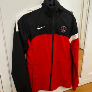 Svart och röd jacka från Nike - Säljer en äkta PSG träningsjacka från Nike. Använd endast ett fåtal gånger. Liten fläck syns på första bilden men tar bort den innan jag säljer den. 🤗
