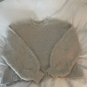 Beige stickad tröja från Gina Tricot - Mysig beige stickad tröja från Gina Tricot i storlek XS. Tröjan har en rund hals och långa ärmar med ribbade muddar. Perfekt för kyliga dagar.