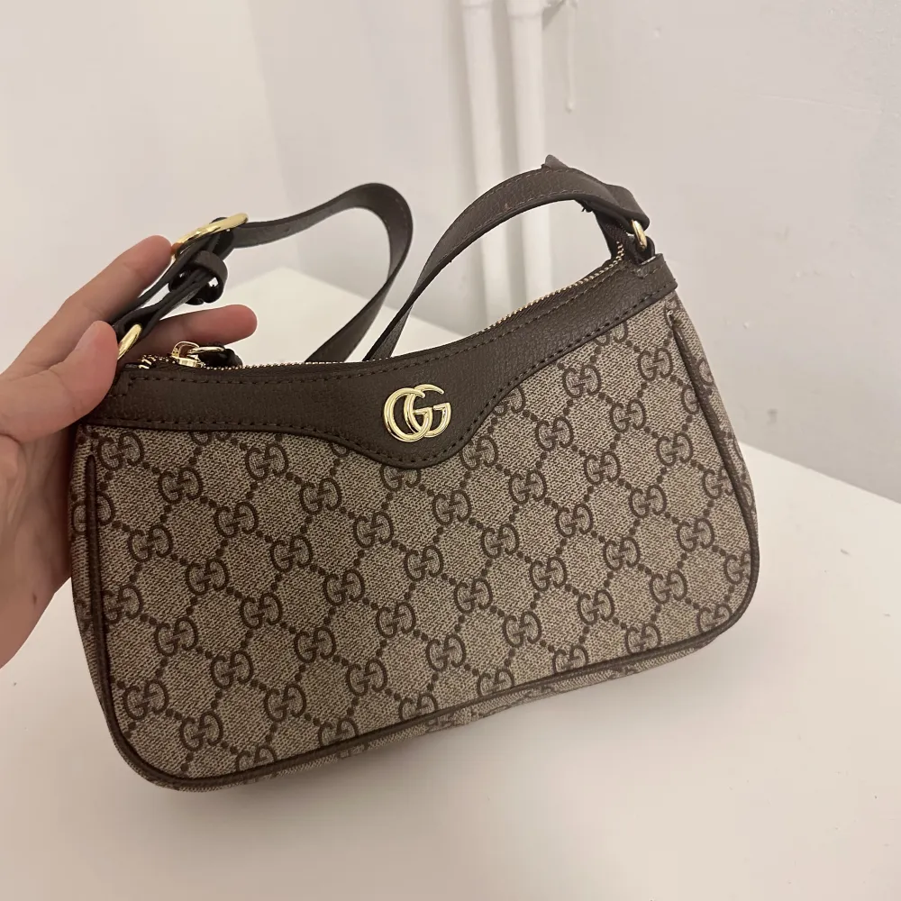 Säljer min favorit Gucci väska, köpt från versitaire collective. Den är i jättefint skick.  Säljer billigt då jag behöver pengar. Skickar ej fler bilder än de som redan finns, för de är tidskrävande. Klicka gärna på köp nu. BUDA EJ MINDRE SÄNKER EJ  . Väskor.