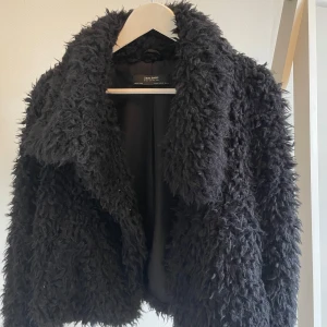 Fluffig jacka - Snygg, fluffig jacka. Svart med tre knappar som går att knäppa. 
