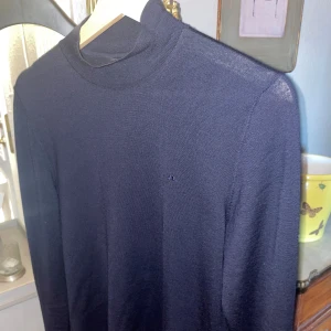 J.Lindeberg Tröja - S - Oanvänd J.Lindeberg tröja. Storlek: S Material: Merino ull  Typ: halvpolo (vik kragen en gång så är det inte en polo längre) Färg: Mörkblå (marin) 